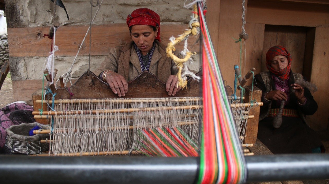 Bhotia women weaving colourful wool and pashmina on a traditional pit loom in a village near Munsiyari